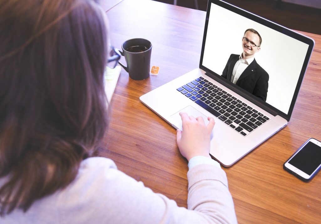 Akademia JA - Kobieta korzystająca z laptopa z mężczyzną na ekranie w ramach mentoringu Gdańsk.
