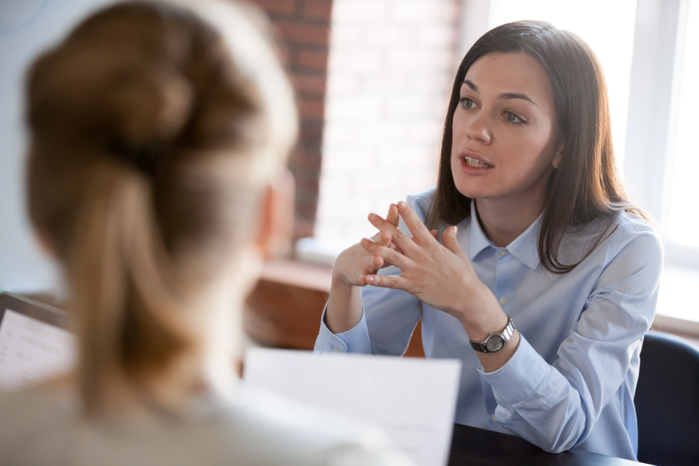 Akademia JA - Kobieta rozmawia z inną kobietą w sopockim biurze coachingowym.